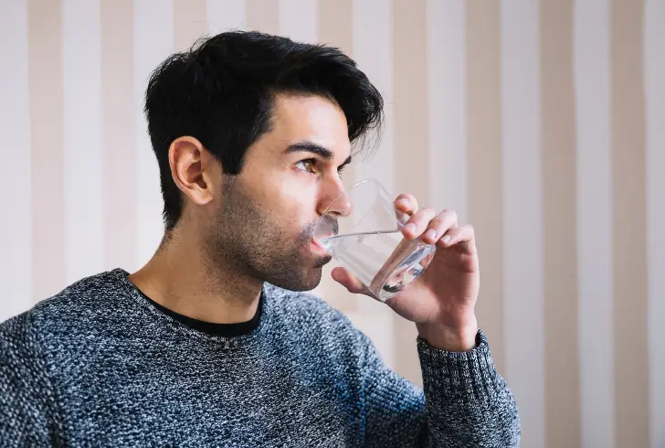 Traveler drinking water after food illness